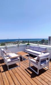 a deck with several chairs and tables on a roof at Eurohotel Diagonal Port in Barcelona