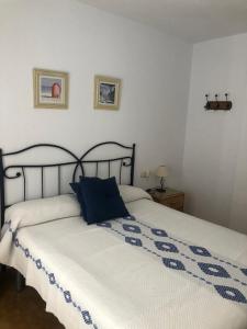 Un dormitorio con una cama con una almohada azul. en BAHIA MAZARRON apartamento en primera linea playa, en Puerto de Mazarrón