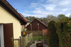 einen Zaun in einem Hof mit einem Haus und einem Zaun sidx sidx in der Unterkunft Geräumiges und gemütliches Haus auf der Höri in Öhningen