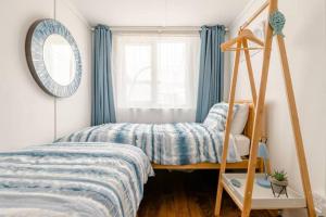 Dormitorio pequeño con cama y espejo en Dog friendly beachside cottage 2 mins to beach with hot tub en Lessingham