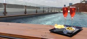 two champagne glasses and a bowl of potato chips next to a swimming pool at Eurohotel Diagonal Port in Barcelona