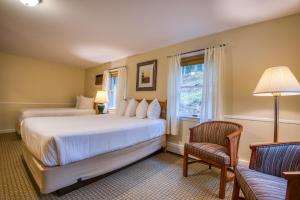 a bedroom with two beds and a chair and a window at Purity Spring Resort in Madison