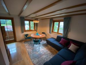 uma sala de estar com um sofá azul e uma mesa em Pia's Nature Retreat em Neukirch