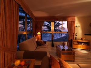 a living room with a couch and a large window at Macdonald Leila Playa Resort in La Cala de Mijas