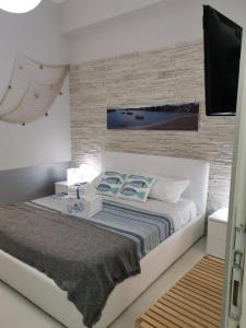 1 Schlafzimmer mit einem Bett und einem TV an einer Backsteinwand in der Unterkunft Al porticciolo in Salerno