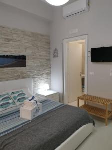 een witte slaapkamer met een bed en een televisie bij Al porticciolo in Salerno