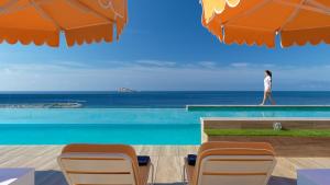 a woman walking on the edge of a swimming pool at H10 Porto Poniente 4 Sup in Benidorm