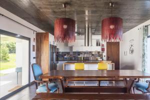 een eetkamer met een houten tafel en stoelen bij Quinta da Morgadia - Azorean Butler in Feteiras