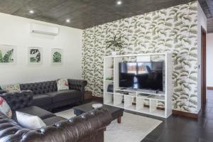 a living room with a couch and a television at Quinta da Morgadia - Azorean Butler in Feteiras
