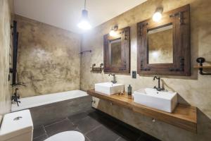 a bathroom with two sinks and a tub and a toilet at Quinta da Morgadia - Azorean Butler in Feteiras +22 photos
