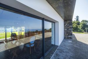 a glass house with a view of the ocean at Quinta da Morgadia - Azorean Butler in Feteiras