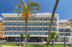 un edificio con palmeras delante en H10 Porto Poniente 4* Sup, en Benidorm