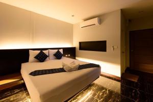 a hotel room with a bed and a nightstand at Skyline Resort in Ban Khlong Lat Bua Khao