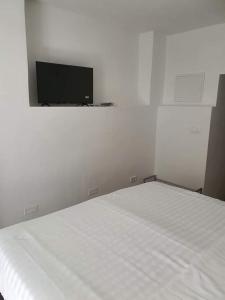 um quarto com uma cama branca e uma televisão de ecrã plano em Aldi 3 em Pula