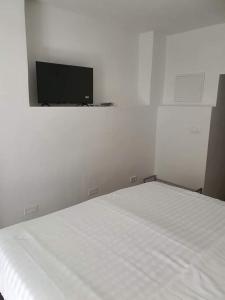 Un dormitorio con una cama blanca y un televisor de pantalla plana. en Aldi 3, en Pula