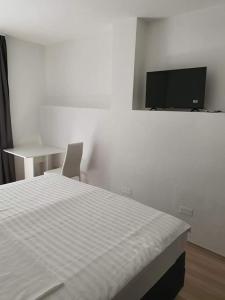 Un dormitorio con una cama y un televisor en la pared. en Aldi 3, en Pula
