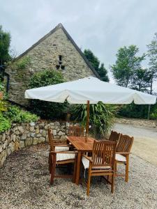 een houten tafel met 2 stoelen en een parasol bij Ferry House Holidays in New Ross