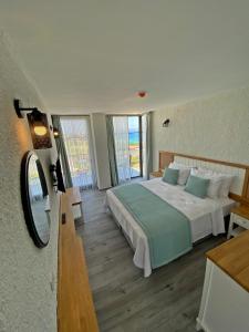 una camera con un grande letto e uno specchio di Vahide Dalyan a Çeşme