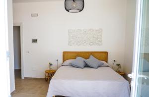 1 dormitorio con 1 cama grande con almohadas azules en B&B La Penisola, en Porto Cesareo