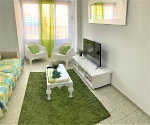 ein Wohnzimmer mit einem TV und einem Sofa in der Unterkunft Bright and Modern Apartment 3 bedroom with Balcony E3EV in Alicante