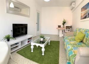 ein Wohnzimmer mit Couch und Fernseher in der Unterkunft Bright and Modern Apartment 3 bedroom with Balcony E3EV in Alicante