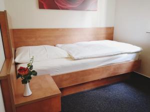 a bed in a room with a vase of flowers on a table at Hotel Meuser in Wiesbaden