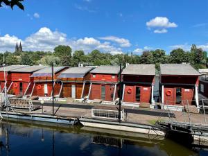 a row of red buildings next to a body of water at HOUSEBOAT GINGER Prague in Prague