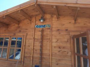 a wooden cabin with a sign on the wall at Cyprus Glamping Park in Ayios Theodhoros