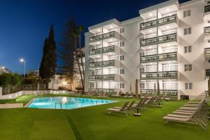 an apartment building with a swimming pool at night at Roca Verde - Playa del Inglés in Playa del Ingles