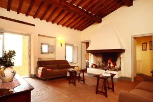 sala de estar con sofá y chimenea en Agriturismo Podere La Casa, en Montalcino