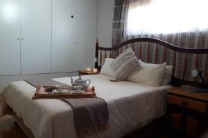 a bedroom with a bed with a tray of food on it at Piketberg Home with a View in Piketberg