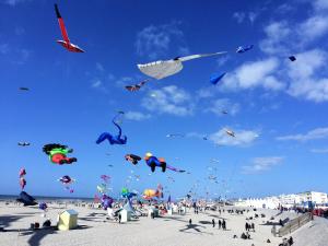 a group of people flying kites on a beach at la Discrète in Berck-sur-Mer