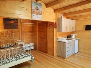 a kitchen in a log cabin with a bed and a sink at Cyprus Glamping Park in Ayios Theodhoros