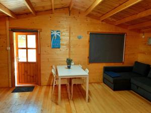 a living room with a table and a black screen at Cyprus Glamping Park in Ayios Theodhoros