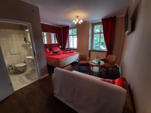 ein Wohnzimmer mit einem Bett und ein Badezimmer in der Unterkunft Pension Havana Club in Weimar