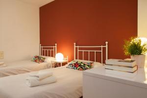 バレンシアにあるSingular Apartments Jorge Juanのベッド2台、テーブル(本付)が備わる客室です。