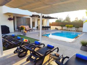 a patio with chairs and a swimming pool at Ilios Villa in Larnaca