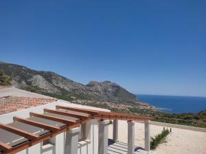 budynek z widokiem na plażę i ocean w obiekcie Hotel Pranos Turismo Rurale Cala Gonone w mieście Cala Gonone