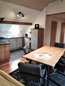 a kitchen with a wooden table in a room at Point Escale in Lontzen