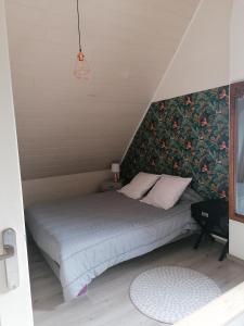 een bed in een kleine kamer met een muur bij À La Maison Du Bonheur in Audruicq