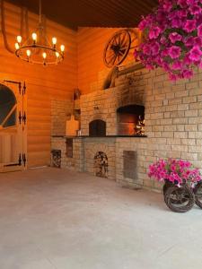 a large room with a brick fireplace and flowers at U Kowola - Gospodarstwo Agroturystyczne in Węglówka