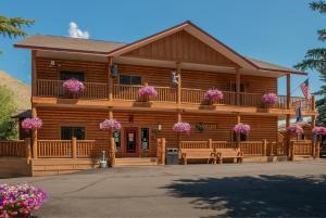 a log cabin with benches in front of it at Cowboy Village Resort in Jackson