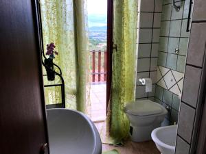 łazienka z wanną, toaletą i oknem w obiekcie Locazione in Appartamento sita in via Ponte di Ferro 2 b w mieście Gualdo Cattaneo