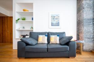 a blue couch with pillows in a living room at Royal William Yard Apartments in Plymouth