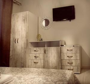 a bedroom with wooden cabinets and a flat screen tv at Haus Viktoria 3 in Limenas