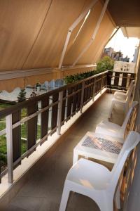 a balcony with white chairs and a table at Haus Viktoria 3 in Limenas