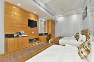 a hotel room with two beds and a flat screen tv at Hotel Vacation Inn in Amritsar