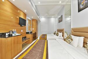 a hotel room with two beds and a tv at Hotel Vacation Inn in Amritsar