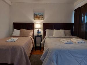 a bedroom with two beds with towels on them at Hotel & Restaurant Fleur de Lis in Concepción de Ataco