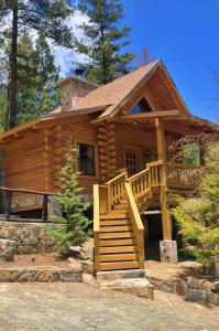 une cabane en rondins avec un escalier en face de celle-ci dans l'établissement Bosques de Monterreal, à Mesa de las Tablas